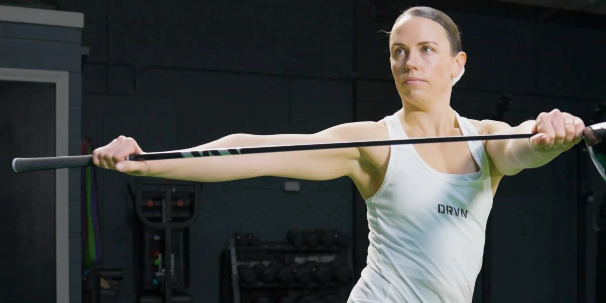Jennifer Dennington training with a golf club overhead